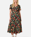 Woman wearing a floral apple print dress on a white background