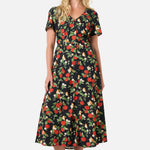 Woman wearing a floral apple print dress on a white background