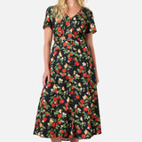 Woman wearing a floral apple print dress on a white background