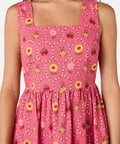 Pink dress with floral and bee pattern on a white background
