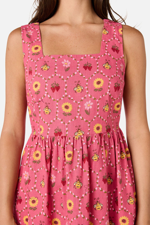 Pink dress with floral and bee pattern on a white background