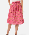 Person wearing a pink floral skirt on a white background