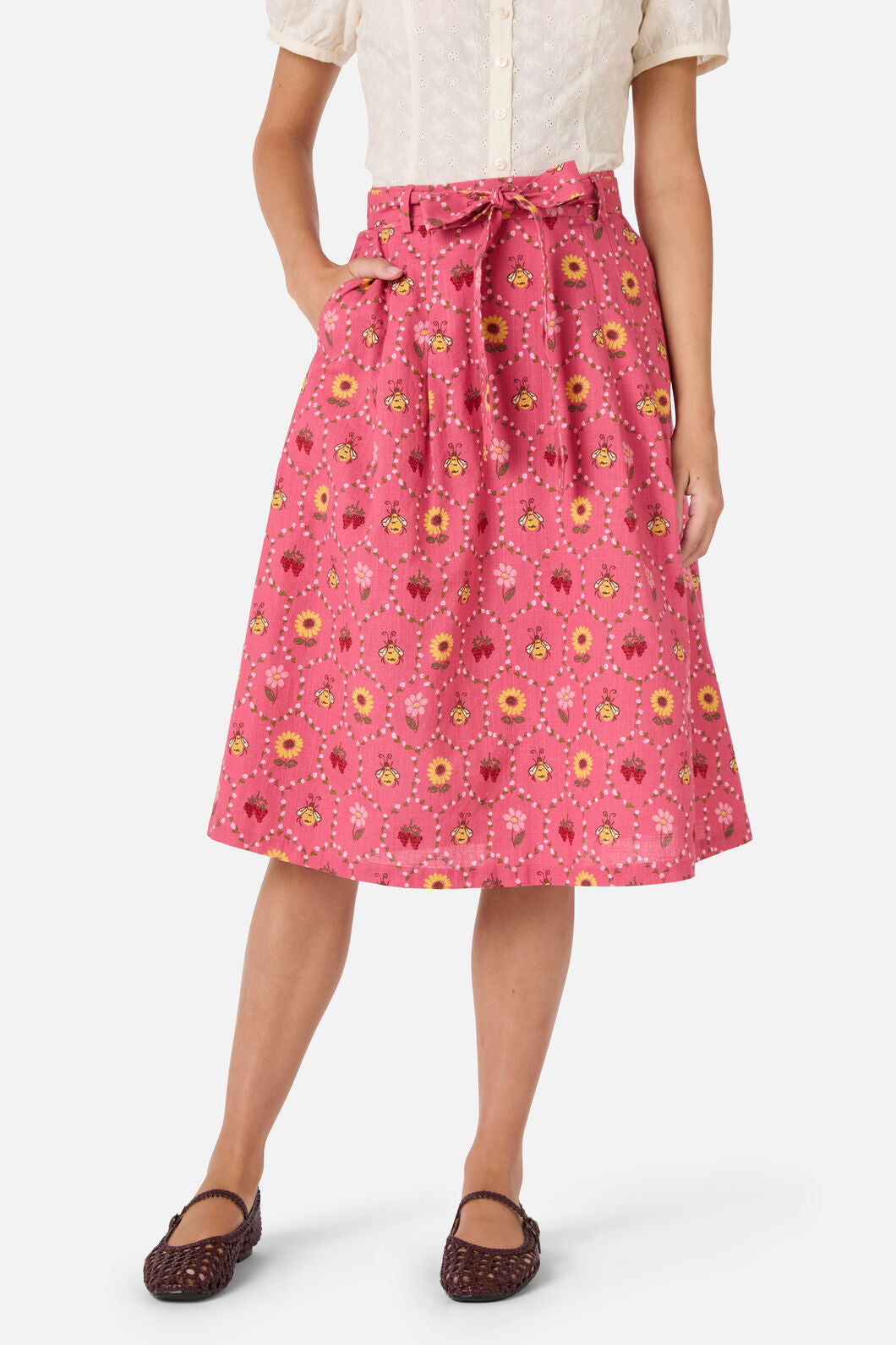 Person wearing a pink floral skirt on a white background