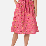 Person wearing a pink floral skirt on a white background