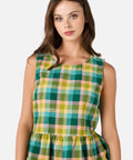 Woman wearing a green and pink plaid sleeveless top on a white background