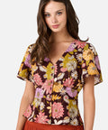 Woman wearing a short sleeve floral blouse with a plain background