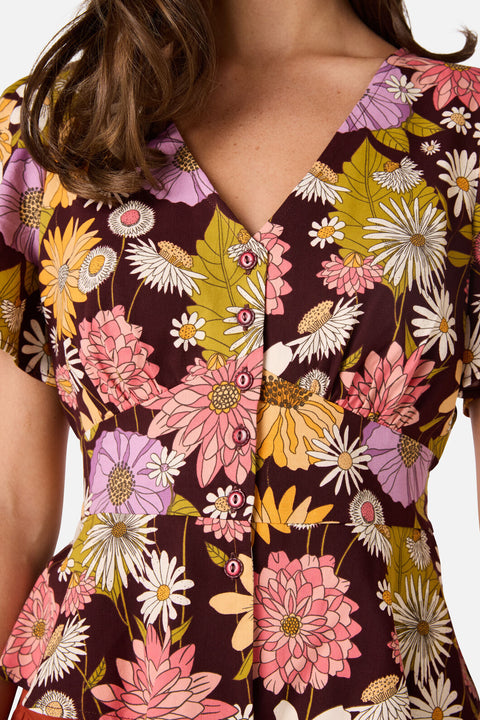 Close-up of a floral blouse with a brown background