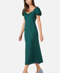 Woman wearing a green dress with puff sleeves on a white background