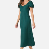 Woman wearing a green dress with puff sleeves on a white background