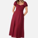 Woman wearing a burgundy dress with puff sleeves on a white background