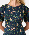 Woman wearing a navy dress with rabbits and colorful floral pattern