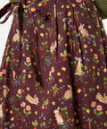 Woman wearing a skirt with rabbit and floral pattern on a brown background