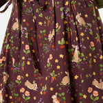 Woman wearing a skirt with rabbit and floral pattern on a brown background