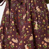 Woman wearing a skirt with rabbit and floral pattern on a brown background