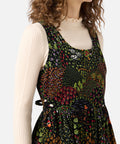 Woman wearing a floral dress over a beige sweater on a white background