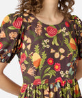 Woman wearing a brown autumn floral dress with short sleeves and a round neckline