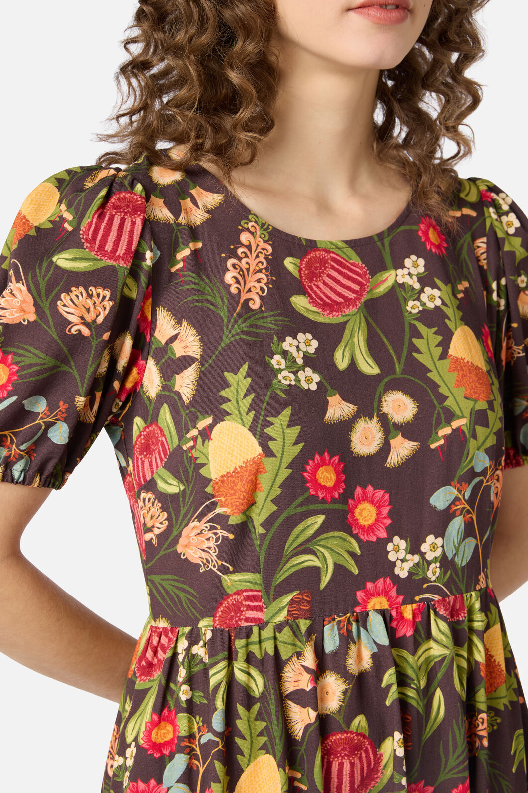 Woman wearing a brown autumn floral dress with short sleeves and a round neckline