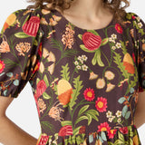 Woman wearing a brown autumn floral dress with short sleeves and a round neckline