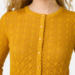 Yellow knitted cardigan with a textured pattern on a white background