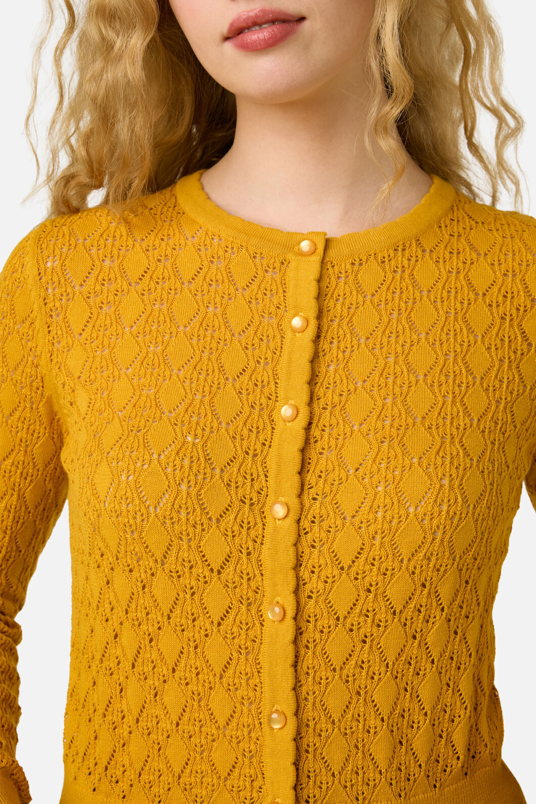 Yellow knitted cardigan with a textured pattern on a white background