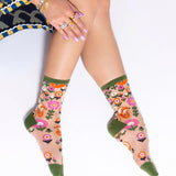 Person wearing floral-patterned socks with a white background