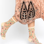 Traditional embroidered garment with floral-patterned socks on a white background