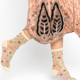 Traditional embroidered garment with floral-patterned socks on a white background