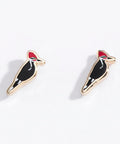 Pair of woodpecker bird-shaped earrings on a white background