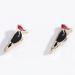 Pair of woodpecker bird-shaped earrings on a white background