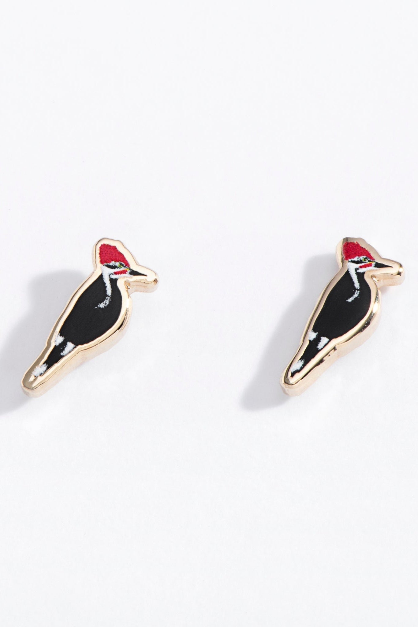Pair of woodpecker bird-shaped earrings on a white background