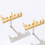Gold 'badass' earrings on a white background