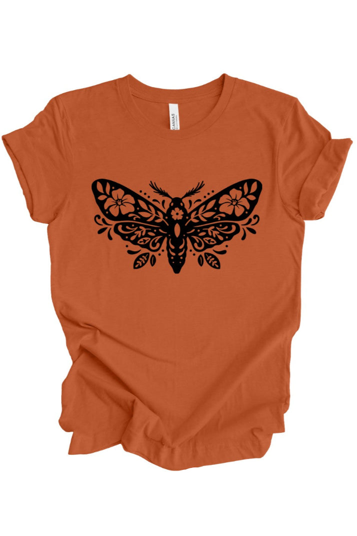 An orange short-sleeve crewneck t-shirt with a black decorative moth graphic printed on the chest, displayed flat against a white background.