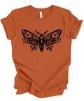 An orange short-sleeve crewneck t-shirt with a black decorative moth graphic printed on the chest, displayed flat against a white background.