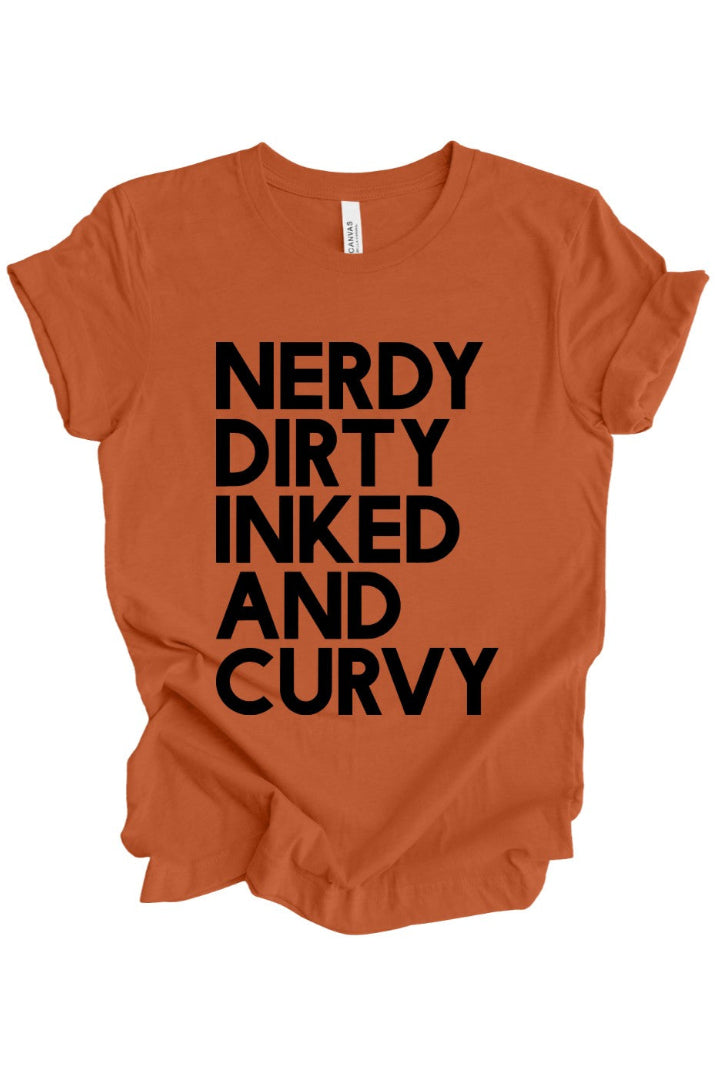 An orange short-sleeve t-shirt with the phrase 'NERDY DIRTY INKED AND CURVY' printed in bold black capital letters on the front, shown against a plain white background.