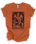 An orange short-sleeve t-shirt with a black graphic print of a woman holding three cats, styled like an Art Nouveau card titled 'MOTHER OF CATS'.