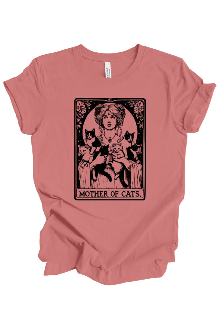 A dusty rose short-sleeve t-shirt with a vintage-style graphic print of a woman holding three black cats, captioned 'MOTHER OF CATS' in an Art Nouveau design. The shirt is shown flat against a plain white background.