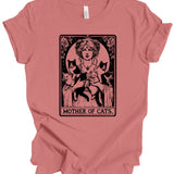 A dusty rose short-sleeve t-shirt with a vintage-style graphic print of a woman holding three black cats, captioned 'MOTHER OF CATS' in an Art Nouveau design. The shirt is shown flat against a plain white background.