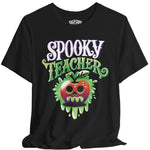 A black short-sleeve t-shirt with a 'Spooky Teacher' graphic on the front, featuring a dripping green slime apple with a skull face. The brand name 'SELF CARE' is printed inside the collar.