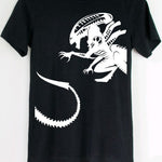 Black t-shirt with a white alien graphic on a hanger against a white background